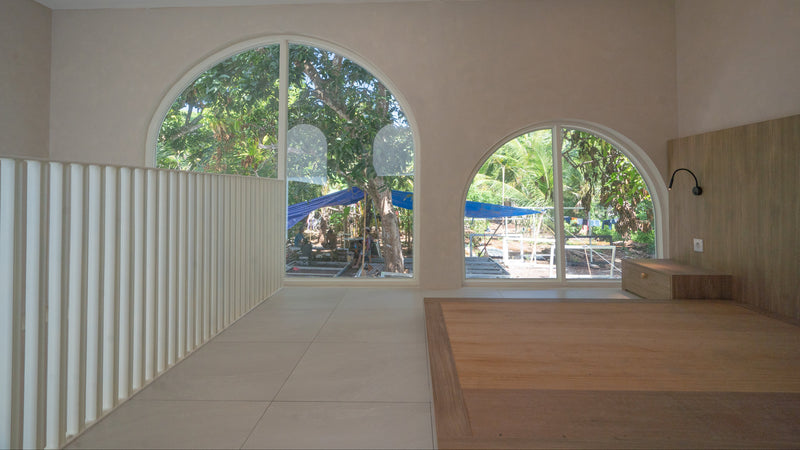Modern interior with large arched windows showing outdoor playground.