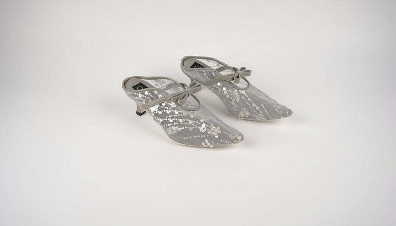 Pair of silver high-heeled shoes on a white background